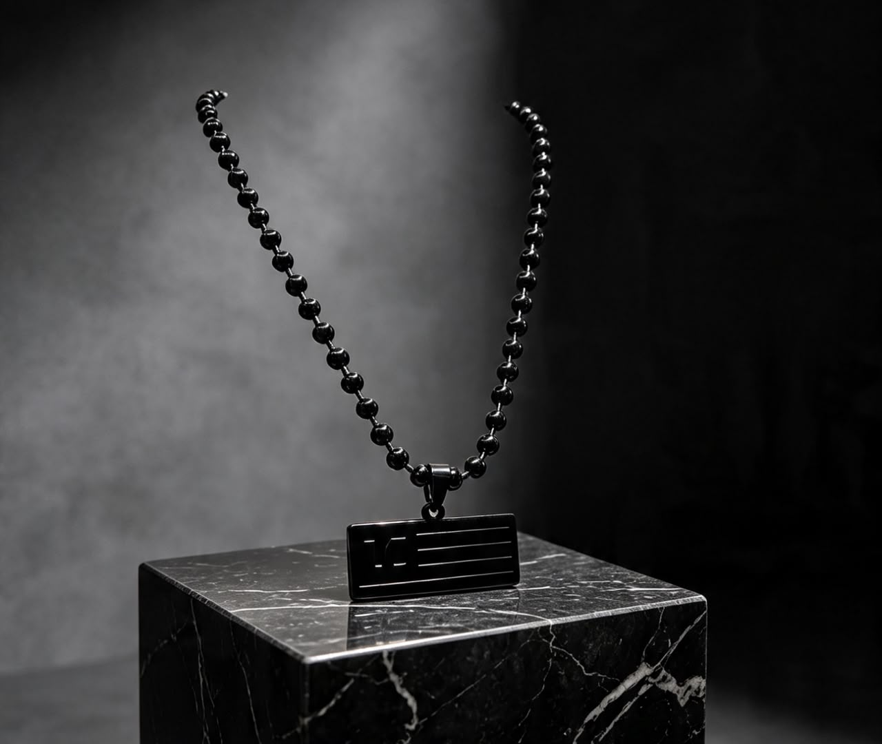 The Blackout Dog Tag Necklace displayed on black marble pedestal